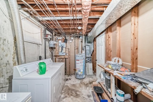 Utility room featuring a water heater, exposed ceiling joists, concrete flooring, and a window with blinds - 3802 52 Street, Wetaskiwin, AB 