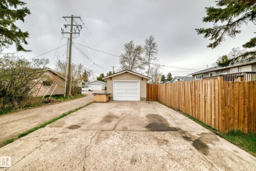 Detached garage with a white overhead door and concrete driveway - 3802 52 Street, Wetaskiwin, AB 