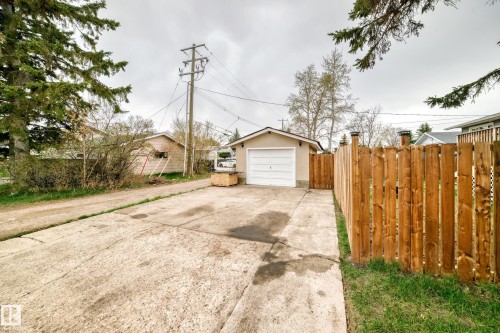 Detached garage with a white overhead door and neutral stucco exterior - 3802 52 Street, Wetaskiwin, AB 