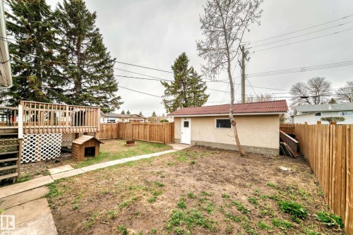 Spacious backyard featuring a multi-level wood deck, a detached garage, and perimeter wood fencing - 3802 52 Street, Wetaskiwin, AB 