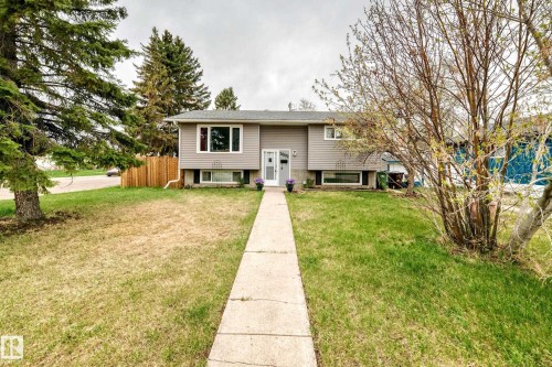 Split-level residence featuring light gray siding, white trim, and a concrete walk to the entry - 3802 52 Street, Wetaskiwin, AB 