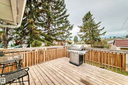 Spacious outdoor deck featuring wooden flooring and a matching wooden railing - 3802 52 Street, Wetaskiwin, AB 