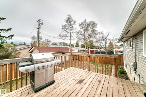 Expansive wood deck with a natural finish, featuring a wooden railing and a spacious backyard area - 3802 52 Street, Wetaskiwin, AB 