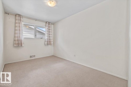 Carpeted room featuring a double window, baseboard trim, and a ceiling-mounted light fixture - 24 Elizabeth Drive, Fort Saskatchewan, AB - Indoor Photo Showing Other Room