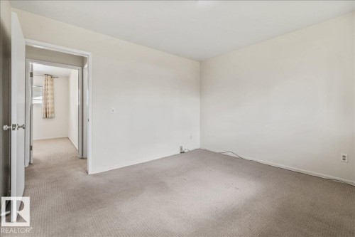Carpeted room with neutral wall tones and white trim - 24 Elizabeth Drive, Fort Saskatchewan, AB - Indoor Photo Showing Other Room