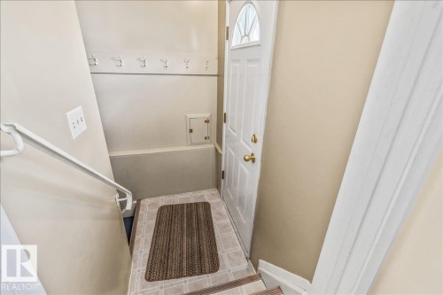 Entryway featuring a white paneled door with an arched glass insert, brass hardware, and a tiled floor - 24 Elizabeth Drive, Fort Saskatchewan, AB - Indoor