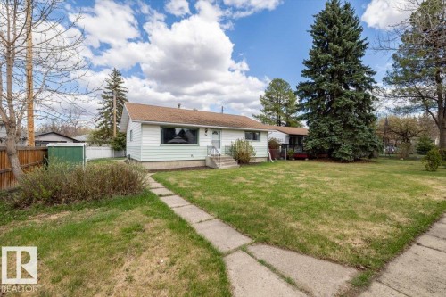 Exterior featuring white siding with light green trim, a brown shingled roof, and a front entry with a white railing - 24 Elizabeth Drive, Fort Saskatchewan, AB - Outdoor