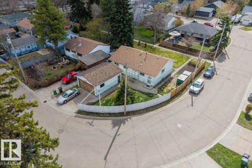 Residential property featuring a detached single-car garage, concrete driveway, and a fenced perimeter - 24 Elizabeth Drive, Fort Saskatchewan, AB - Outdoor With View