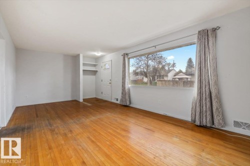 Hardwood flooring throughout a spacious room with light gray walls - 24 Elizabeth Drive, Fort Saskatchewan, AB - Indoor Photo Showing Other Room