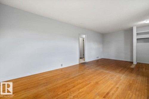 Spacious interior with wood-finish flooring, light gray walls, and recessed lighting - 24 Elizabeth Drive, Fort Saskatchewan, AB - Indoor Photo Showing Other Room