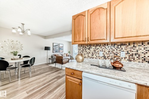 Kitchen with wooden cabinetry, mosaic tile backsplash, and a white dishwasher - 10329 150 Street, Edmonton, AB - Indoor Photo Showing Kitchen