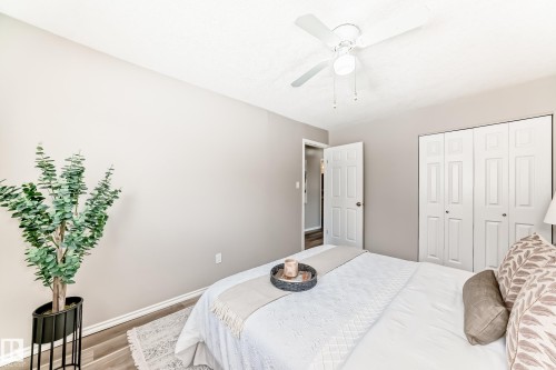 This room features light-colored walls, wood-look flooring, and a ceiling fan - 10329 150 Street, Edmonton, AB - Indoor Photo Showing Bedroom