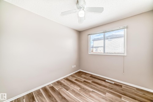 This room features light-colored walls, a ceiling fan with a light fixture, and wood-style flooring - 10329 150 Street, Edmonton, AB - Indoor Photo Showing Other Room