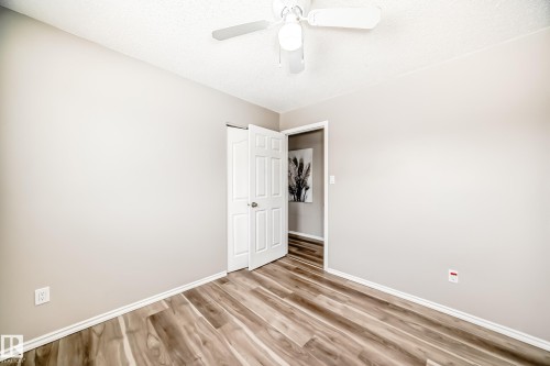 This room features light-colored walls, wood-look flooring, and a ceiling fan with an integrated light fixture - 10329 150 Street, Edmonton, AB - Indoor Photo Showing Other Room