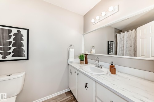 This bathroom features a spacious vanity with an integrated sink and a large mirror - 10329 150 Street, Edmonton, AB - Indoor Photo Showing Bathroom