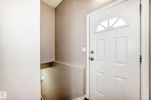 The property features an entryway with light-colored walls and a white paneled door with an arched window - 10329 150 Street, Edmonton, AB - Indoor Photo Showing Other Room