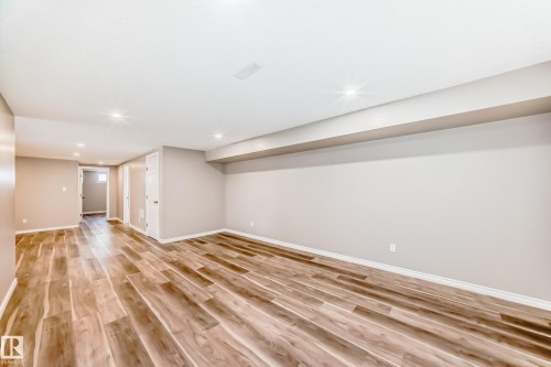 The property features a spacious room with wood-look flooring and recessed lighting - 10329 150 Street, Edmonton, AB - Indoor Photo Showing Other Room