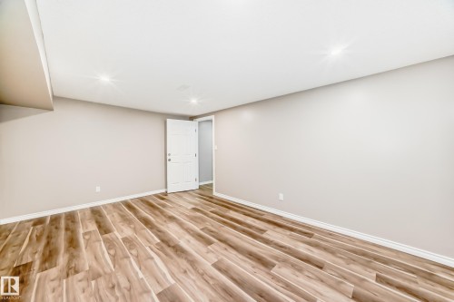 This room features light-colored walls, recessed ceiling lighting, and wood-look flooring - 10329 150 Street, Edmonton, AB - Indoor