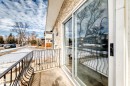 The property features a private balcony with a wrought iron railing, an exterior wall with textured siding, and a large sliding glass door - 10329 150 Street, Edmonton, AB  - Outdoor 