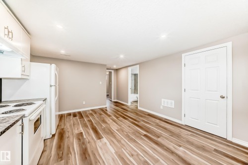 The property features an open living space with wood-look flooring and light-toned walls - 10329 150 Street, Edmonton, AB - Indoor Photo Showing Kitchen