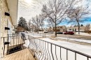 The property features a balcony with black metal railings, offering a view of the street with other properties and bare trees - 10329 150 Street, Edmonton, AB  - Outdoor 
