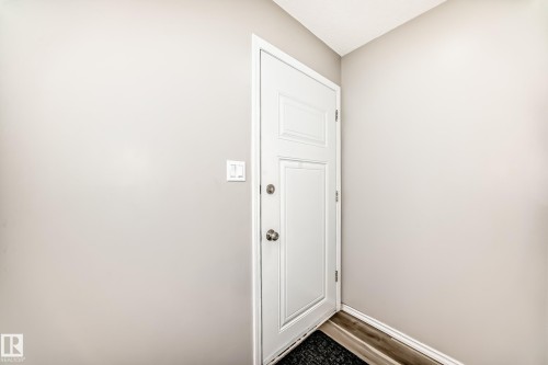 Entryway featuring a white paneled door with brushed nickel hardware, light gray walls, and wood-look flooring - 10329 150 Street, Edmonton, AB - Indoor Photo Showing Other Room