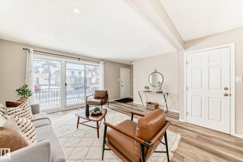 Bright living area featuring a large sliding glass door, recessed lighting, and wood-look flooring - 10329 150 Street, Edmonton, AB - Indoor Photo Showing Living Room
