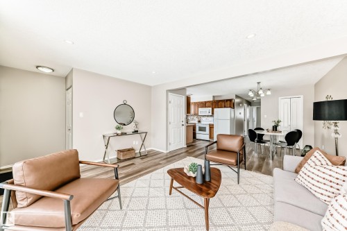 The living area features light-colored walls and wood-style flooring throughout - 10329 150 Street, Edmonton, AB - Indoor Photo Showing Living Room