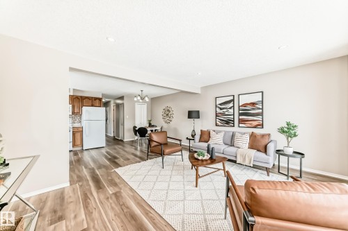The living area features wood-look flooring, a light-colored area rug, and recessed lighting - 10329 150 Street, Edmonton, AB - Indoor Photo Showing Living Room