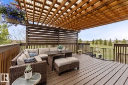 Spacious outdoor deck featuring a slatted wood pergola, privacy screen, and wood-finish decking - 