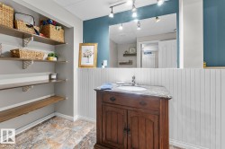 Bathroom vanity featuring a stone countertop and an undermount sink - 