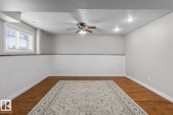 Spacious room featuring wood-finish flooring, white beadboard wainscoting, a ceiling fan, recessed lighting, and a window with blinds - 