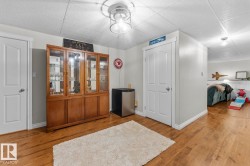 Spacious interior featuring wood-finish flooring, light grey painted walls, white trim, and white paneled doors - 