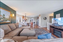 Open-concept living space featuring wood-finish flooring, recessed lighting, and a built-in media console with an integrated electric fireplace - 