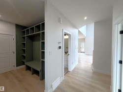 Built-in green mudroom storage with bench seating and shelving - 