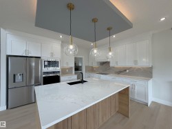 Kitchen featuring a large central island with a light wood-finish base and a light-toned countertop - 