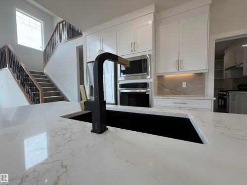 Kitchen island featuring a black sink and matte black faucet - 202 Edgewater Circle, Leduc, AB - Indoor Photo Showing Kitchen With Double Sink