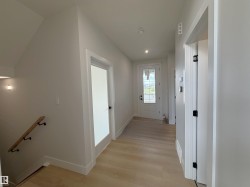 Entryway featuring light wood-finish flooring, white trim, and a glass-paneled entry door - 