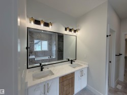 Dual vanity with white cabinetry, wood-finish drawers, and quartz countertops - 