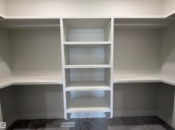 Walk-in closet featuring built-in shelving, hanging rods, and perimeter countertops - 