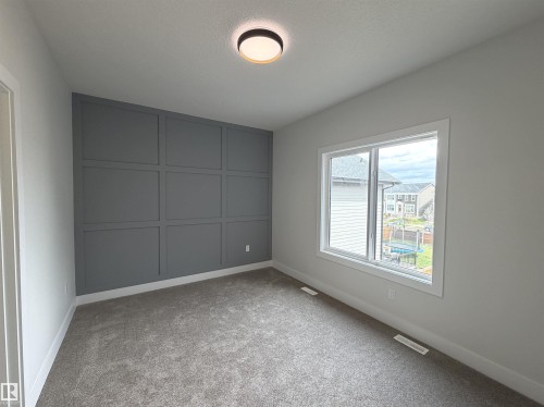 Accent wall featuring decorative paneling - 202 Edgewater Circle, Leduc, AB - Indoor Photo Showing Other Room