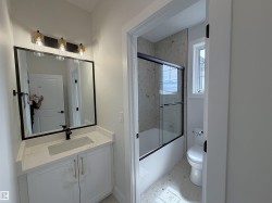 Contemporary bathroom vanity featuring a rectangular undermount sink, a white countertop, and a matte black faucet - 