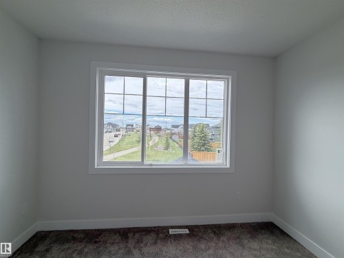 White trimmed window with gridded panes - 202 Edgewater Circle, Leduc, AB - Indoor Photo Showing Other Room