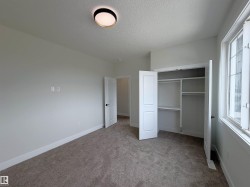 Room featuring light gray wall paint, neutral carpeting, and a modern flush-mount ceiling light - 