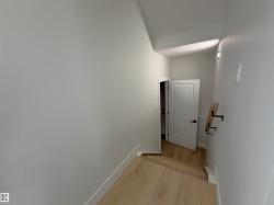 Stairwell featuring wood-finish flooring, white walls, and a recessed ceiling light - 