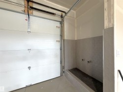 Attached white sectional garage door with overhead track system - 