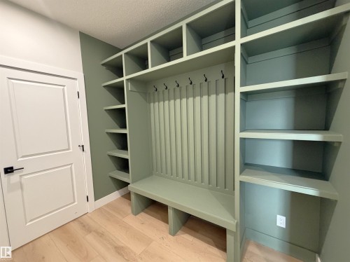 Built-in mudroom storage featuring a bench, coat hooks, and extensive shelving - 202 Edgewater Circle, Leduc, AB - Indoor