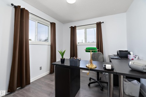 Bright room with two windows, wood-finish flooring, white baseboards, and a flush mount ceiling light - 17 Camelot Avenue, Leduc, AB - Indoor Photo Showing Office