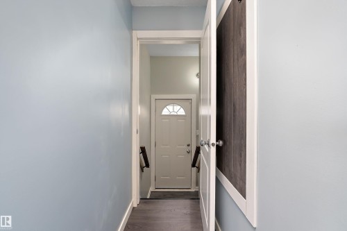 Entryway corridor featuring wood-finish flooring, light blue wall paint, and white trim - 17 Camelot Avenue, Leduc, AB - Indoor Photo Showing Other Room