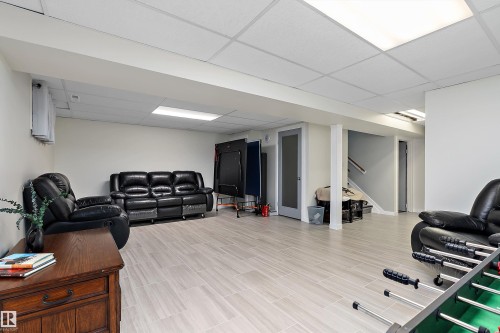 Spacious lower-level area featuring light-toned tile flooring, recessed lighting, drop ceiling, and painted white walls - 17 Camelot Avenue, Leduc, AB - Indoor
